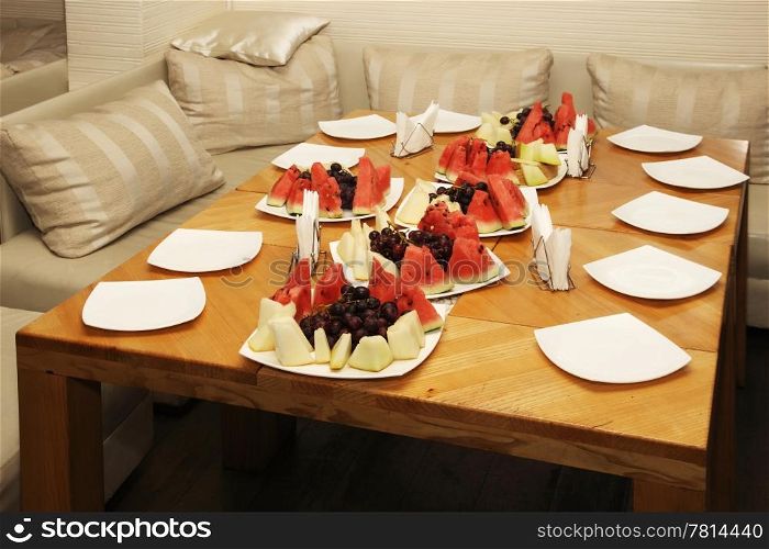 lay the table with melon, watermelon and grapes