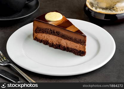 Layered chocolate cake with brewing coffee on stone table