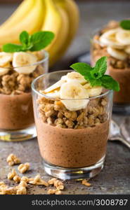 Layered chocolate chia pudding parfait with banana, granola and yogurt, dessert