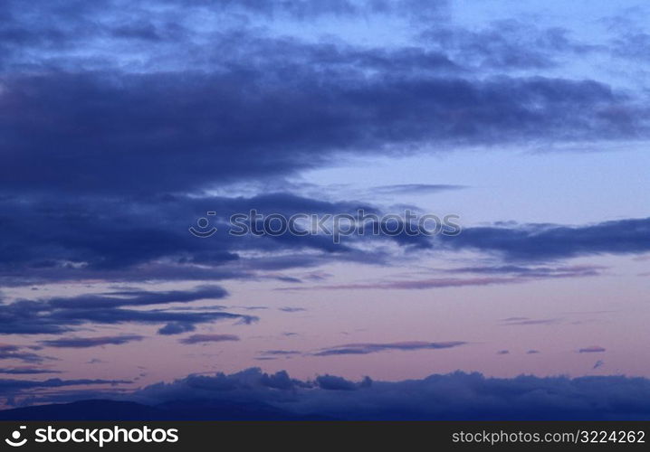 Layers Of Dark Clouds In A Purple Sky