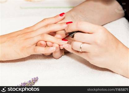 Laying nail polish on a woman&rsquo;s hands