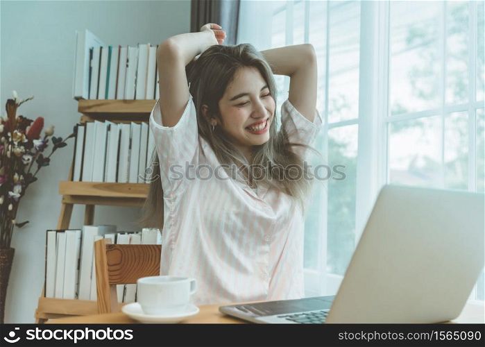 Lazy bored asian woman using laptop in the morning.