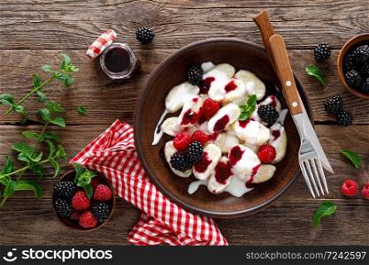 Lazy dumplings, vareniki with fresh berries. Boiled cottage cheese gnocchi with sour cream, raspberry and blackberry. Traditional ukrainian cuisine