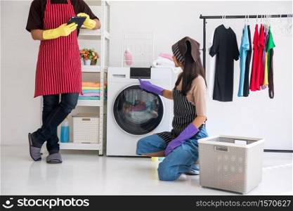 Lazy man playing tablet while Asian woman doing laundry chore housework. Housewife get angry to her husband. Selective focus at girl finger