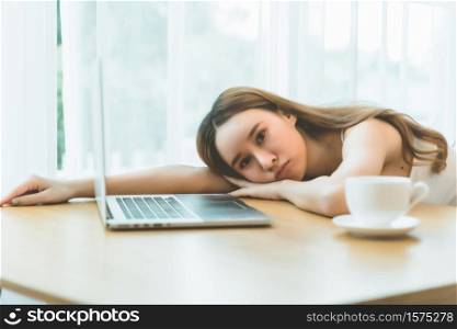 Lazy woman sleeping over a laptop in a desk.
