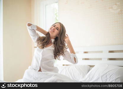 Lazy young woman sitting in bedroom