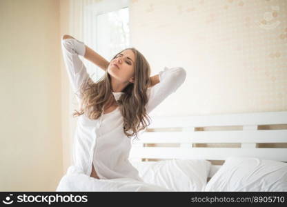 Lazy young woman sitting in bedroom