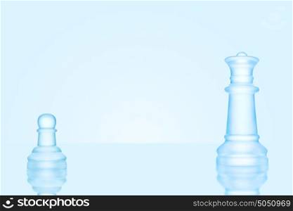 Leadership and bravery concept; an icy frosted single pawn staying against a queen on chessboard.