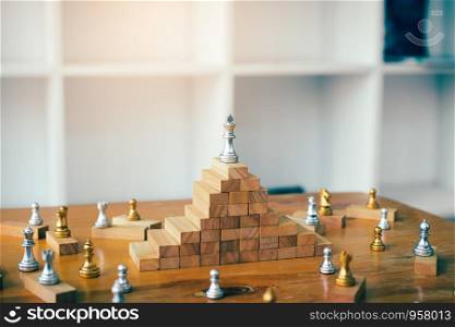 Leadership concept with king chess on top wooden block.