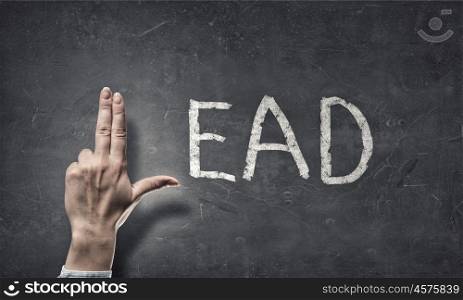 Leadership concept. Word lead written on wall and fingers instead of letter L