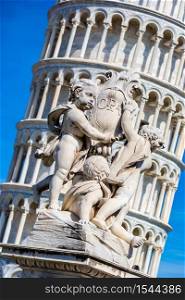Leaning tower in Pisa with statue of angels in a summer day in Italy