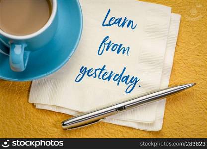 Learn from yesterday - handwriting on a napkin with a cup of coffee