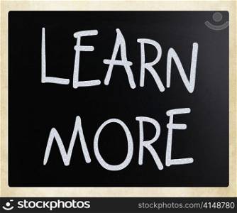 ""Learn More" handwritten with white chalk on a blackboard"