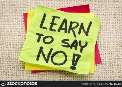 learn to say no advice or reminder on a green sticky note against burlap canvas
