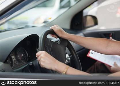 Learner driver student driving car with instructor