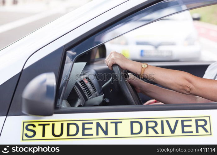 Learner driver student holding steering wheel during driving lesson