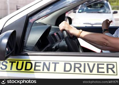 Learner driver student holding steering wheel during driving lesson
