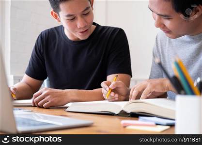 Learning, education and school concept. Young men studying for a test or an exam. Tutor books with friends. Young students campus helps friend catching up and learning.