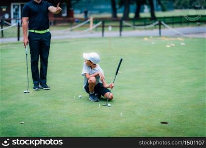 Learning Golf. Boy practicing putting with instructor