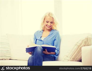 leasure and home concept - smiling middle-aged woman reading book and sitting on couch at home