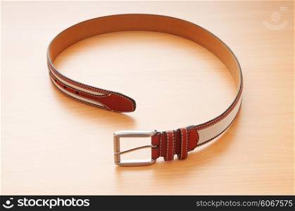 Leather belt on the wooden background