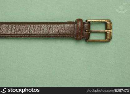 leather belt with a buckle on a green background