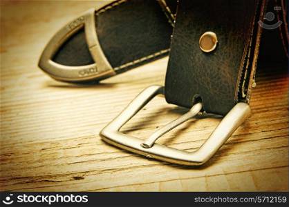 leather belt with a buckle on a wooden board