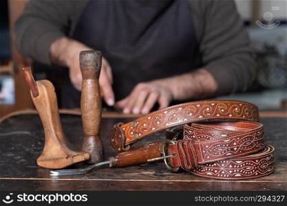 leather belts with leather craftsman tools on table