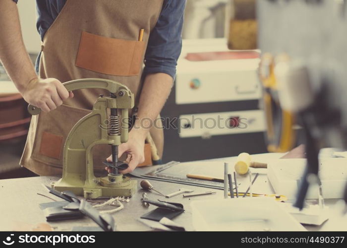 Leather craft workshop owner at his work place