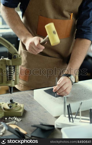 Leather craft workshop owner at his work place