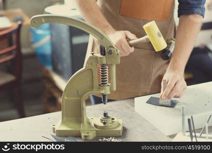 Leather craft workshop owner at his work place