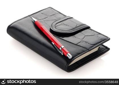 Leather notebook and pencil on white reflective background.