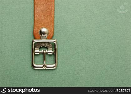 leather strap with a buckle on a green background