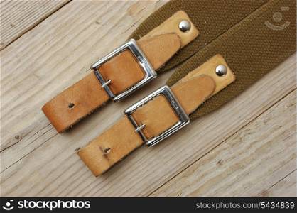 leather strap with a buckle on a wooden board