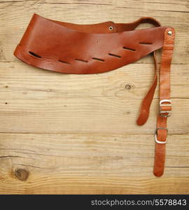 leather strap with a buckle on a wooden board