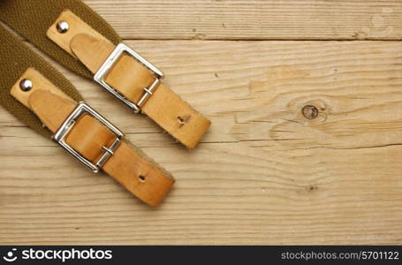 leather strap with a buckle on a wooden board