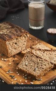 Leavened bread, whole grain rye bread with pumpkin and sunflower seeds. Leaven starter on table. Authentic sourdough homemade bread-organic bio product. Handcrafted product, slices of bread on board
