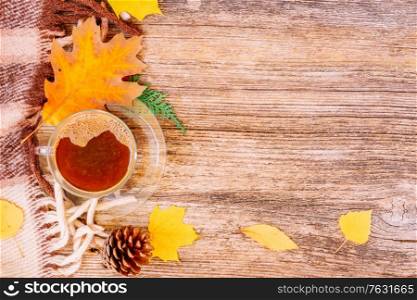 leaves and coffee on wooden top view autumn background, retro toned. Fall leaves autumn background