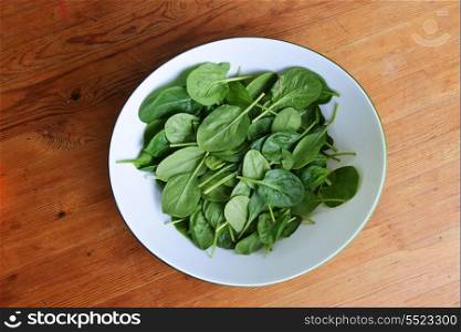 leaves of fresh green spinach in bowl