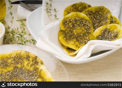lebanese manouche or manoushe ,lebanese pizza with thyme and sesame seeds,zaatar, and extra virgin olive oil on top
