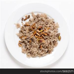 Lebanese spiced rice with minced beef and garnished with freshly toasted nuts on a plate viewed from above