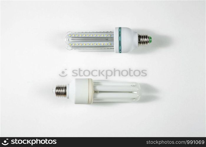 led and fluorescent energy saving lamps on white isolated background. on the glass