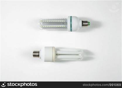 led and fluorescent energy saving lamps on white isolated background. on the glass