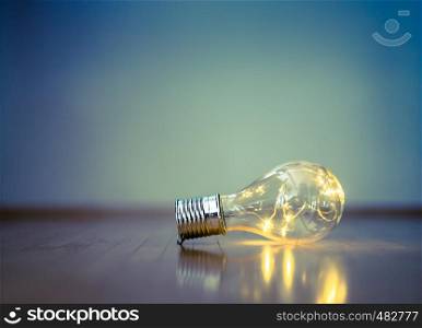 LED light bulb is lying on the wooden floor. Symbol for ideas and innovation. Copy space.