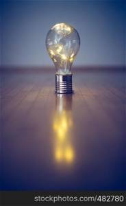 LED light bulb is lying on the wooden floor. Symbol for ideas and innovation. Copy space.