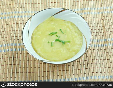 Leek soup a bowl on wooden background