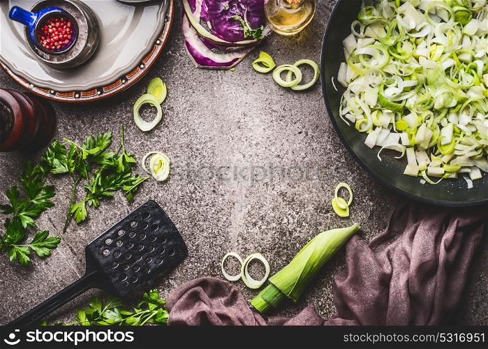 Leeks meal eating and cooking . Pan with sliced leeks on kitchen table background with tools and ingredients, top view, frame