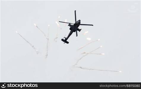 LEEUWARDEN, THE NETHERLANDS - JUN 10, 2016: Dutch AH-64 Apache attack helicopter firing off flares during the Royal Netherlands Air Force Days