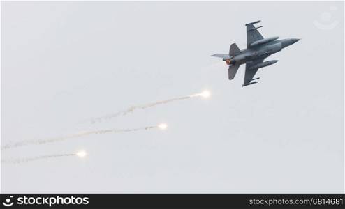 LEEUWARDEN, THE NETHERLANDS - JUN 11, 2016: Dutch F-16 fighter jet firing off flares during a flyby on it's European debut at the Royal Netherlands Air Force Days