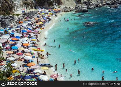 Lefkada island, Agiofilli beach, Greece - August 29 2016: Summer holidays, many people on the beach, sea swimming. Lefkada island, Agiofilli beach, Greece. Summer holidays, many people on the beach, sea swimming
